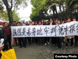 律师王宇和活动人士拉横幅要求异地审判范木根。(照片来源:现场活动人士)