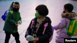 戴着口罩的孩子们在上海火车站。(2020年3月5日)