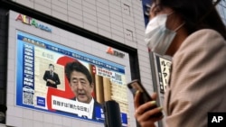 一个公共屏幕上在转播日本首相安倍晋三的记者会。(2020年5月25日)