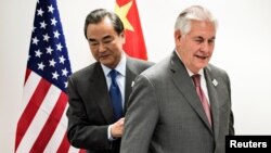泰勒森国务卿(右)和王毅外长(左)在德国波恩举行的21国集团外长会议的间隙进行会晤之前走向各自的座位。(2017年2月17日)