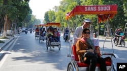中国游客在越南河内乘坐人力车观光。中国是赴越南旅游人数最多的国家(2016年12月1日)。
