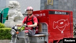 中国电子商务公司京东的首席执行官兼创始人刘强东2014年6月16日在北京开电动三轮车为客户送货,这是为了纪念公司成立日。