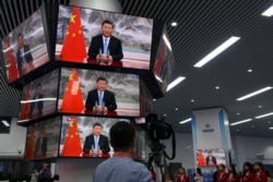 上海举行的中国国际进出口展销会媒体中心的多面电视屏幕正在播放中国领导人习近平的讲话。(2021年11月4日)