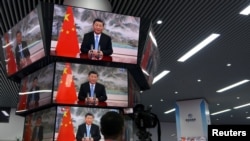 资料照片:上海举行的中国国际进出口展销会媒体中心的多面电视屏幕正在播放中国领导人习近平的讲话。(2021年11月4日)