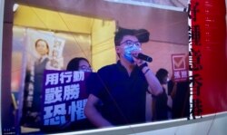 反送中运动两周年义卖活动回顾过去两年香港人的抗争历史,一张大型照片为前香港众志秘书长黄之锋去年7月参与民主派立法会35+初选拉票的情况。 (美国之音 汤惠芸拍摄)