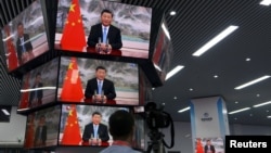 上海举行的中国国际进出口展销会媒体中心的多面电视屏幕正在播放中国领导人习近平的讲话。(2021年11月4日)