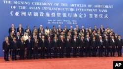 中国国家主席习近平(右九)在北京人民大会堂与参加亚洲基础设施投资银行创始成员国签字仪式的各国代表合影。(2015年6月29日)