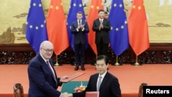 2019年11月6日,法国总统马克龙与中国国家主席习近平见证欧盟农业和农业发展事务专员菲尔·霍甘与中国商务部长钟山在北京人大会堂签署协议。(路透社)