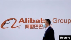 2020年11月23日,在浙江乌镇举行世界互联网大会期间,一个路人从阿里巴巴公司图标前走过。
