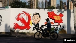 2018年9月28日,上海一条街上的宣传画,包括习近平的漫画形象、中共党徽和中国地图,还有文字“民族团结,社会稳定,国家统一”