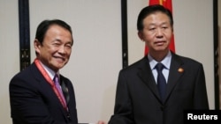 日本副首相兼财务大臣麻生太郎(左)在亚洲开发银行2017年会期间与中国时任财政部长肖捷会谈