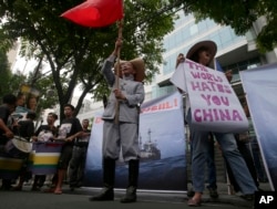 2014年6月菲律宾人在中国驻马尼拉领事馆外示威,有人手持标语:“世界恨你,中国”