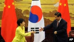 韩国总统朴槿惠(左)与中国国家主席习近平在北京人民大会堂握手。(2013年6月27日资料照)