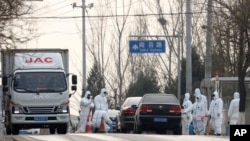 北京郊区房山地区发现非洲猪瘟后,身穿防护服的防疫人员在通往出现疫情的村庄道路上设卡。(2018年11月23日)