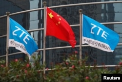 中国企业中兴通讯在深圳的总部外飘扬的该公司旗帜和中国国旗。(2016年4月28日)