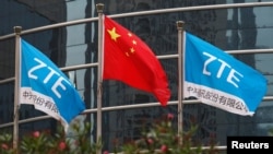 中国企业中兴通讯在深圳的总部外飘扬的该公司旗帜和中国国旗。(2016年4月28日)
