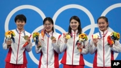 资料照片:中国女子4x200米自由泳接力队员在日本东京举行的2020年夏季奥运会上举着金牌合影。(2021年7月29日)