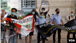 梁国雄(左二)等民主派积极分子香港区域法院外手持横幅抗议政治迫害。(2020年7月30日)