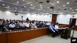 在这张由山东省济南市中级人民法院公布的照片中,失势政要薄熙来在警察的左右看管下出庭接受审判。(2013年8月22日)