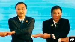 老挝万象举行的东盟会议上,中国总理李克强(左)和菲律宾总统杜特尔特(右)手拉手(资料照片)。