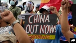 在海牙国际仲裁庭就菲律宾与中国海洋权利纠纷作出裁决五周年之际,抗议者举着标语在中国驻菲律宾马卡蒂领事馆外集会。(2021年7月12日)