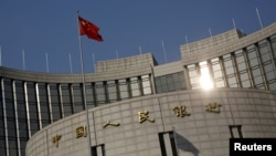 资料照:中国国旗在中国人民银行在北京的总部外飘扬。
