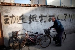 资料照:一名男子骑车走过上海街头一处拆迁地。(2010年12月1日)