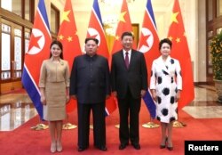 中国国家主席习近平和夫人彭丽媛在北京人大会堂同朝鲜国务委员会委员长金正恩和夫人李雪主合影。(2018年3月28日)