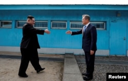 2018年4月27日,韩国总统文在寅和朝鲜领导人金正恩在韩国朝鲜之间的非军事区内的板门店休战区握手。