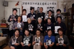 天安门母亲们手持在八九六四事件中丧生的亲人照片 (照片来自天安门母亲网站)
