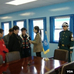 游客在非军事区停战谈判会议室内听导游讲解(美国之音王南拍摄)