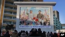 朝鲜人聚集在金日成像和金正日像前,纪念金正日去世三周年(2014年12月17日)