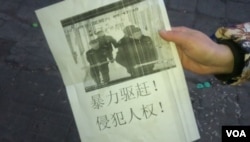 遭驱赶的移民手持要求人权的传单抗议北京当局暴力清退。(美国之音叶兵拍摄)
