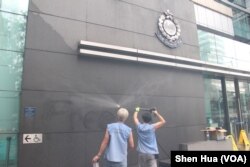 2019年6月27日,工人在高压清洗消除昨晚抗议者喷涂的标语(美国之音申华拍摄)