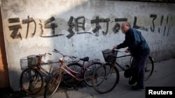 资料照:一名男子骑车走过上海街头一处拆迁地(2010年12月1日)