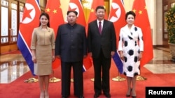 中国国家主席习近平和夫人彭丽媛在北京人大会堂同朝鲜国务委员会委员长金正恩和夫人李雪主合影。(2018年3月28日)