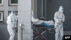 中国湖北省武汉市收治新型冠状病毒肺炎病人的金银潭医院医务人员在运送一名病人。(2020年1月18日)
