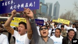 失踪马航班机中国乘客的亲属举着标语牌游行走向马来西亚驻北京大使馆(2014年3月25日)