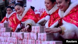 在中国杭州一个公园里,工作人员在一场有奖游戏中摆放百元钞票(2016年1月26日)