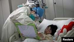 2013年4月,一个染上新型H7N9禽流感病毒的小女孩在北京的一家医院里接受治疗。(资料照片)