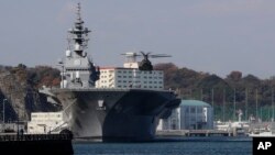 一架日本自卫队的直升机准备降落在日本海上自卫队的出云级直升机驱逐舰甲板上(2016年12月6日)