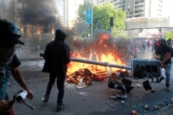 智利反政府示威者在圣地亚哥街头焚烧交通灯。(2019年10月30日)