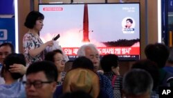 韩国火车站乘客观看大屏幕电视,正播放朝鲜发射导弹节目(2019年7月31日)