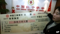 资料照:中国红十字会的雇员举着中国电脑公司联想集团捐助的50万美元支票的放大版本。(2005年1月4日)