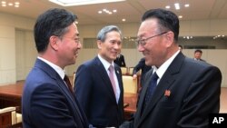 朝鲜统一部部长金养建(右)在板门店举行会谈之后与韩国统一部长官洪容杓交谈。(2015年8月25日)