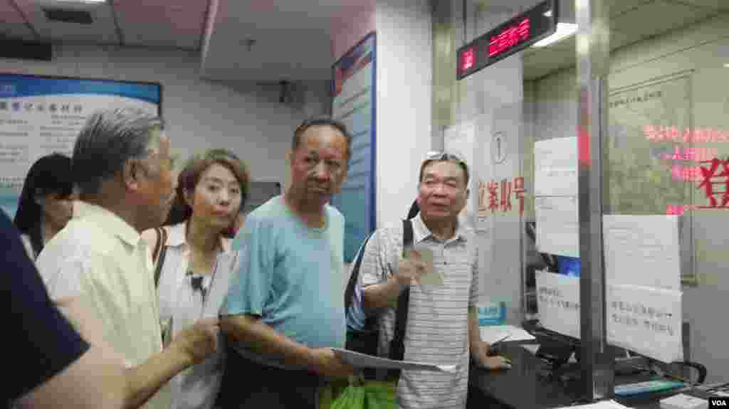 (右起)副总编辑王彦军、执行主编丁东、秘书长杜明明、执行主编冯立三在法院立案取号窗前。
