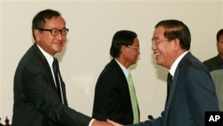 柬埔寨首相洪森(左)和反对党领袖桑兰西(右)在举行议会会谈之前握手的照片。