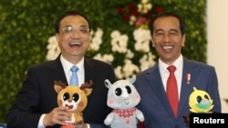 中国总理李克强和印度尼西亚总统佐科·维多多在印尼总统府分享轻松时刻,手持2018年亚运会的吉祥物。(2018年5月7日)