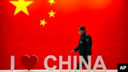 一名保安走过中国国旗和我爱中国字样的宣传片。(2019年10月31日)