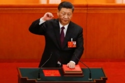 中国国家主席习近平在连任第二个任期时左手抚按宪法,右手举拳,宣誓就任。(2018年3月17日)